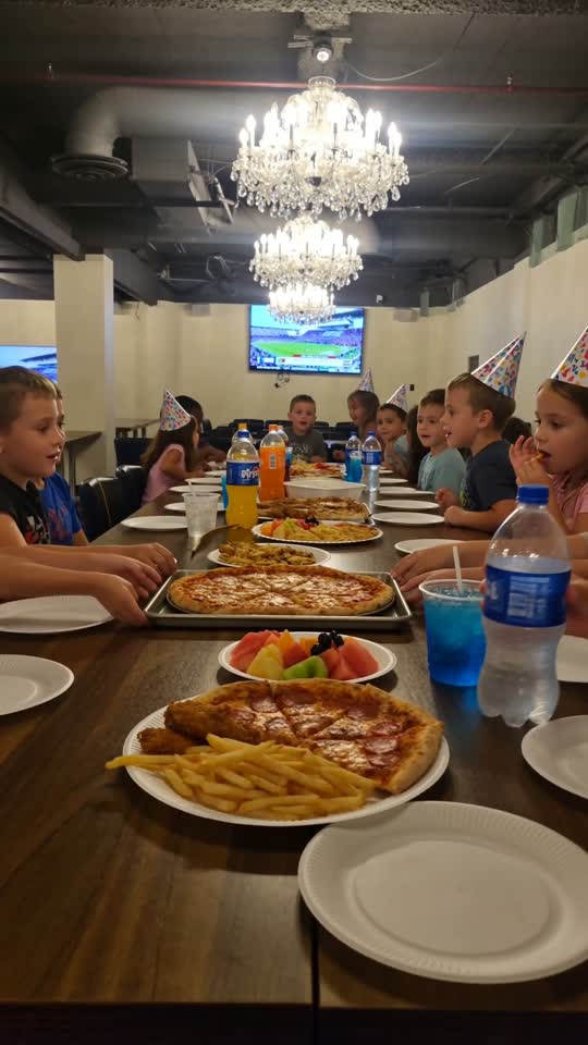Kids eating pizza together in the private party room at Les Trois Monkeys.